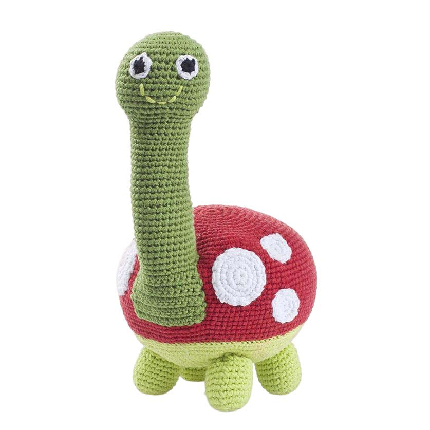 Crocheted turtle toy with a red shell on a white background