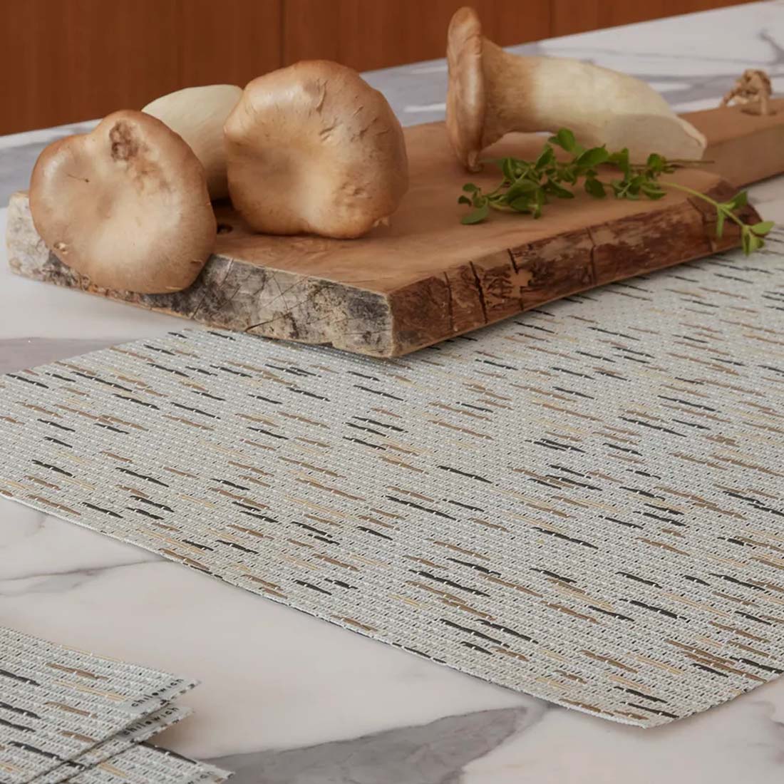 A white woven placemat with a subtle striped pattern