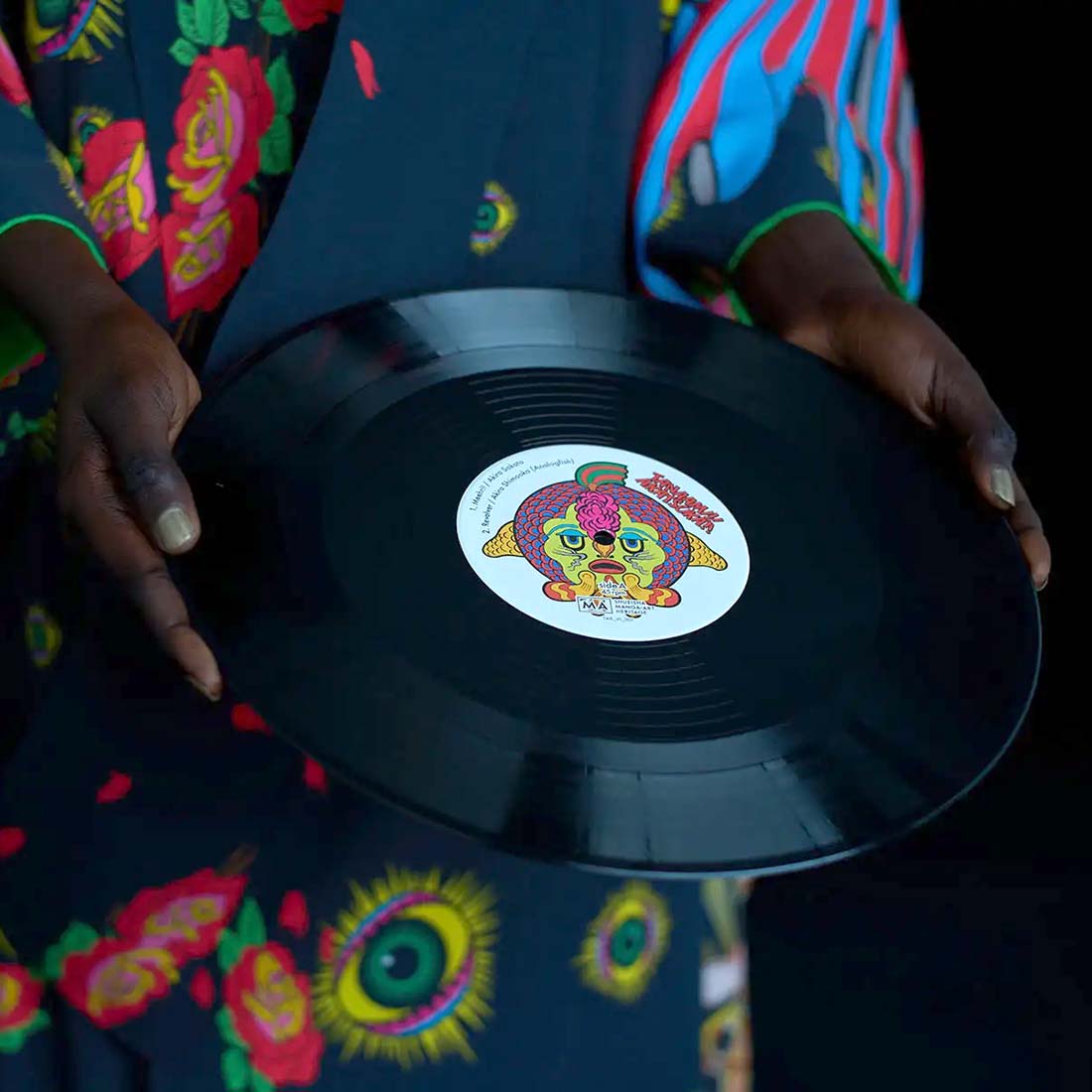 Vinyl record cover with colorful floral design and a person's silhouette. TANAAMI!! AKATSUKA!! / Revolver - The Sound Track