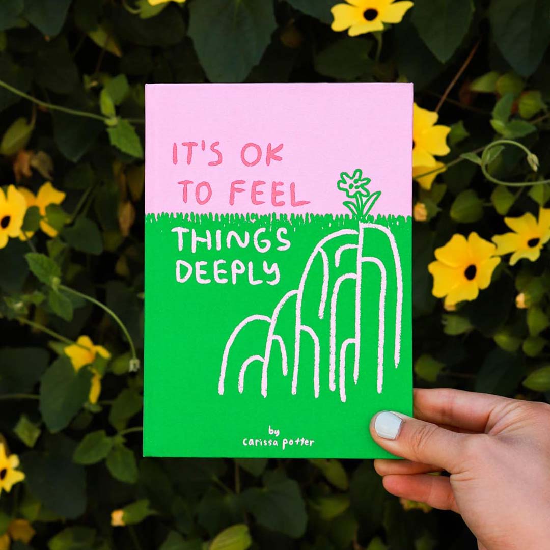 The image depicts the cover of a book titled "It's OK to Feel Things Deeply" by Carissa Potter. The cover design is simple yet striking, featuring a vibrant green background with white illustrations of stylized grasses.