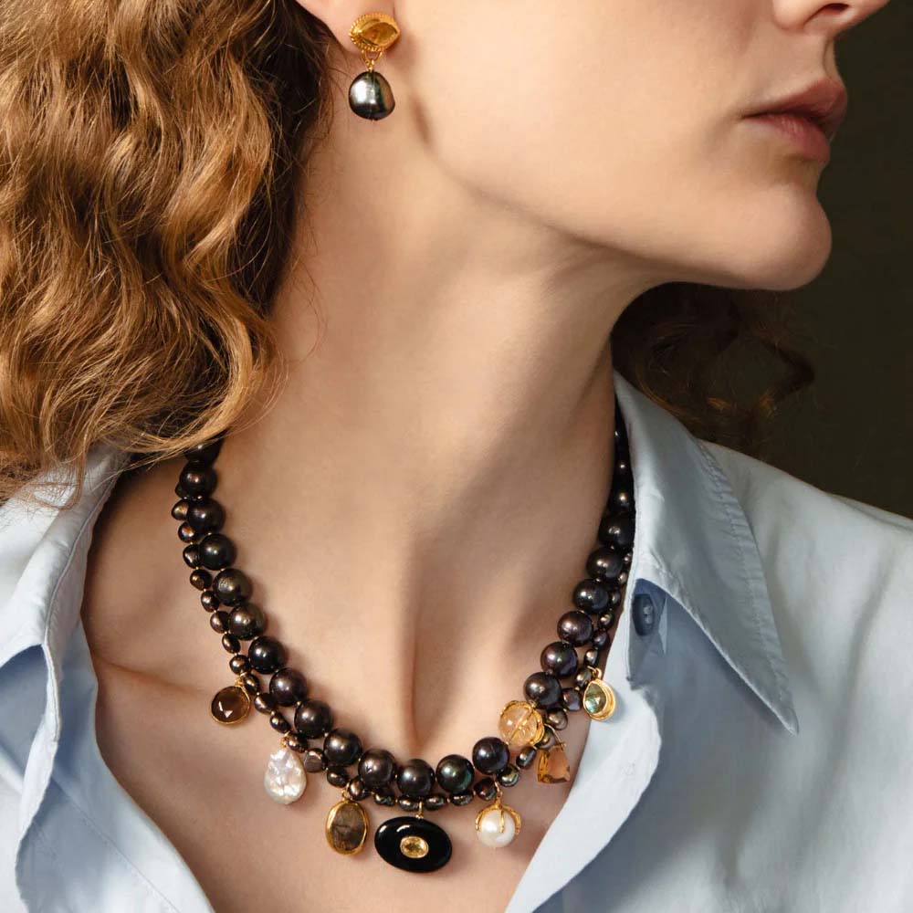 Necklace with brown beads and gold accents on a white background