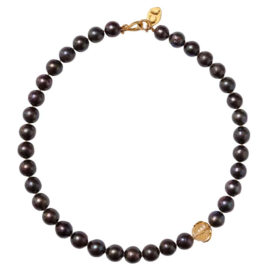 Black pearl necklace with gold clasp on a white background