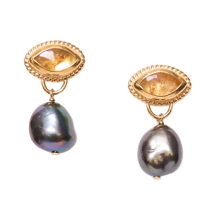 Gold earrings with teardrop-shaped gemstones and pearls on a white background
