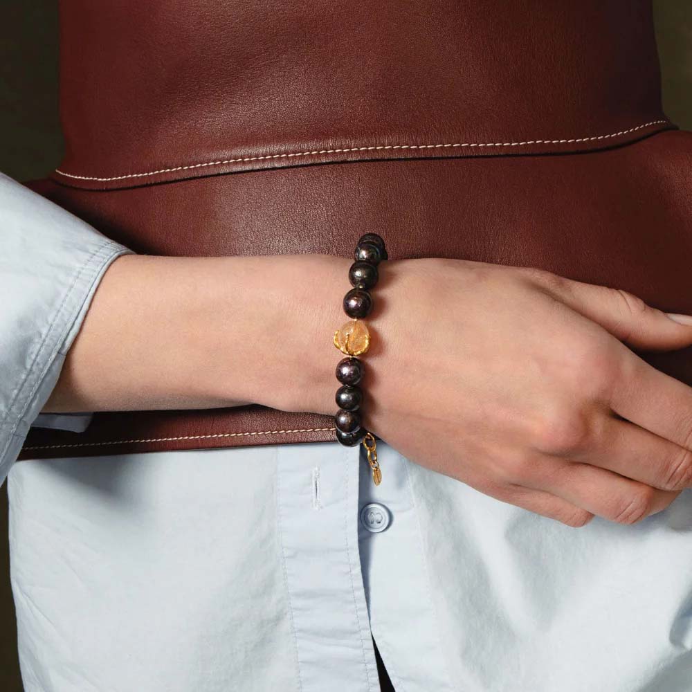 Pearl bracelet with gold clasp on a white background