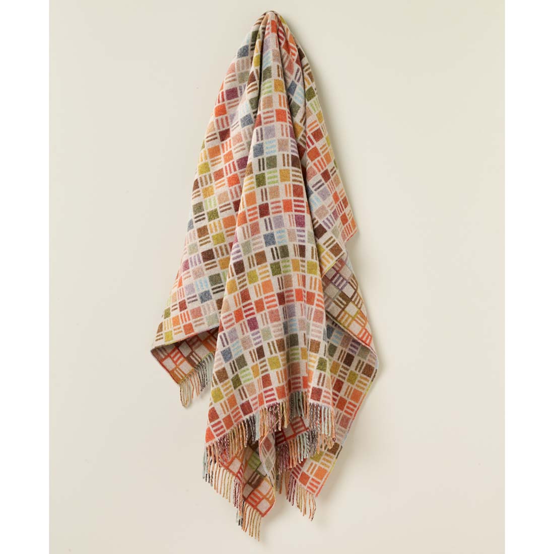 Multicolored checkered blanket with fringes on a white background