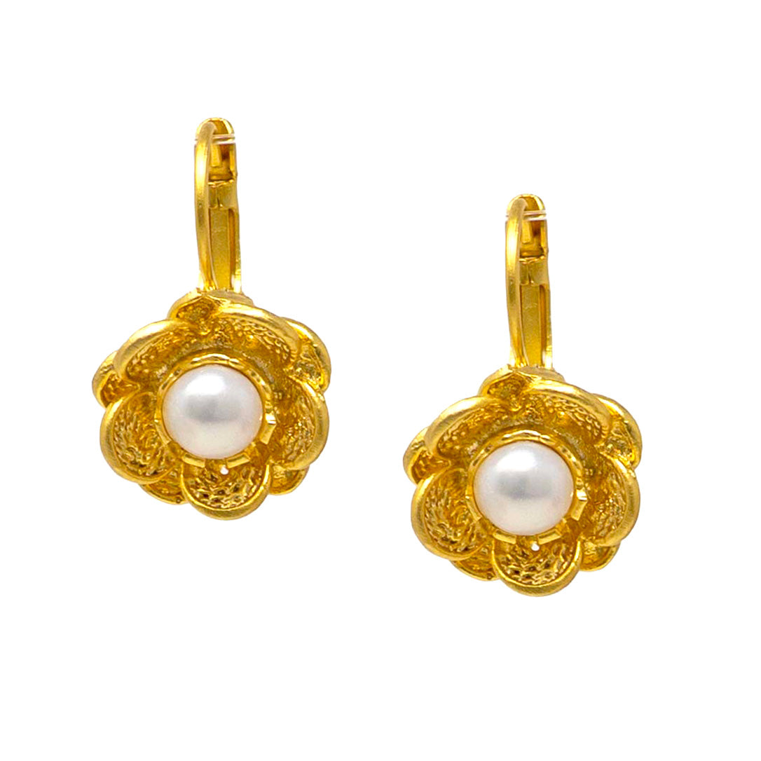 Gold earrings with pearl centers on a white background