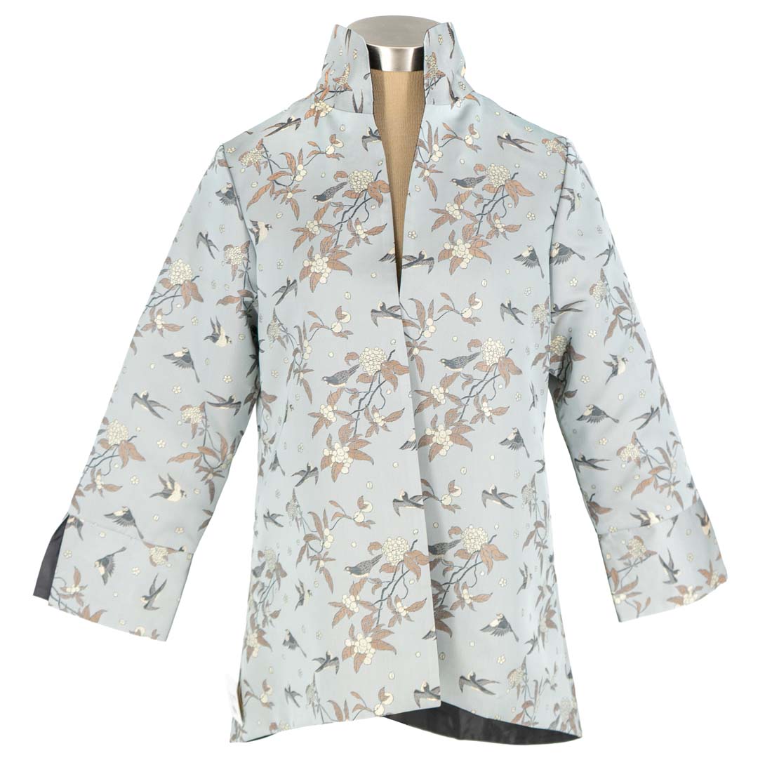 Floral-patterned raincoat on a mannequin against a white background
