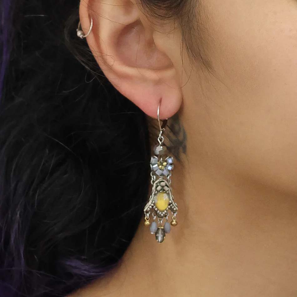 Pair of ornate earrings with beads on a white background