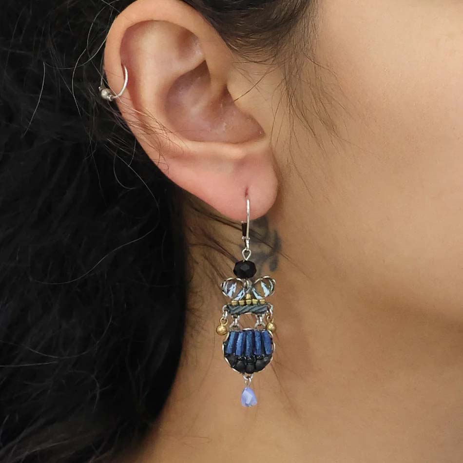 Pair of earrings with blue and black beads on a white background