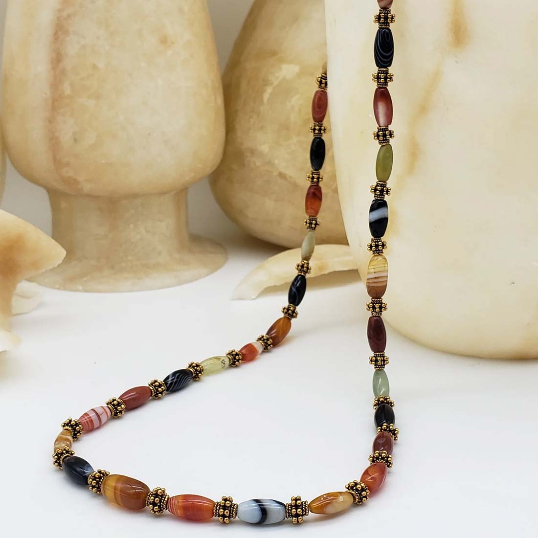 Necklace with multicolored beads and gold accents on a white background