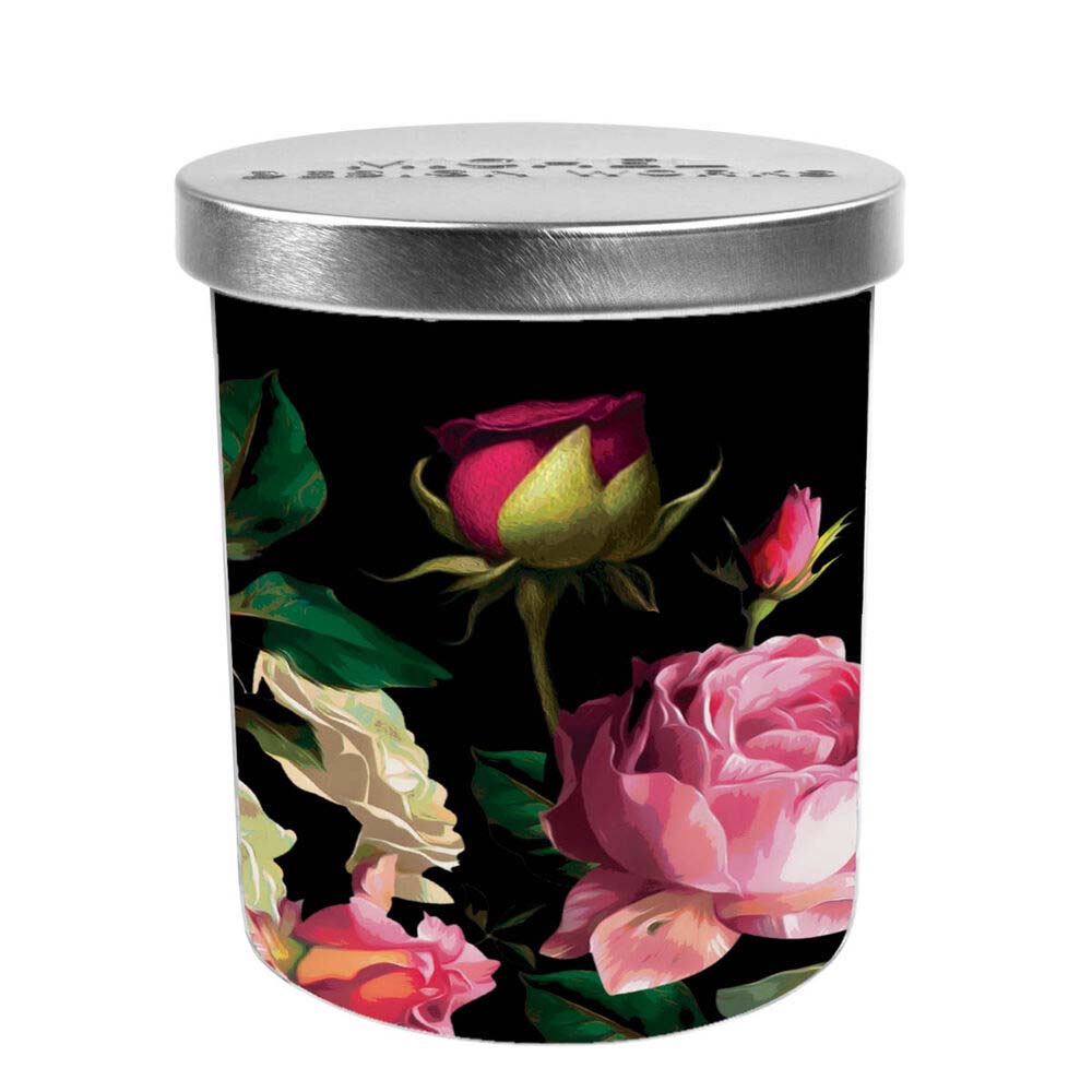 Candle in a decorative tin with floral design on a black background