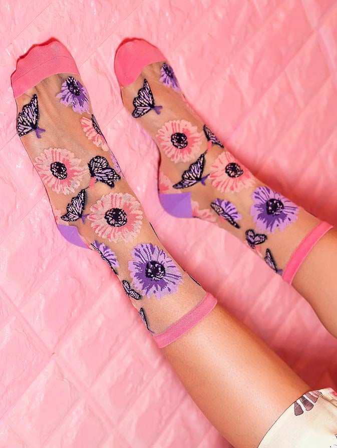 Sheer socks with floral and butterfly pattern on a pink background