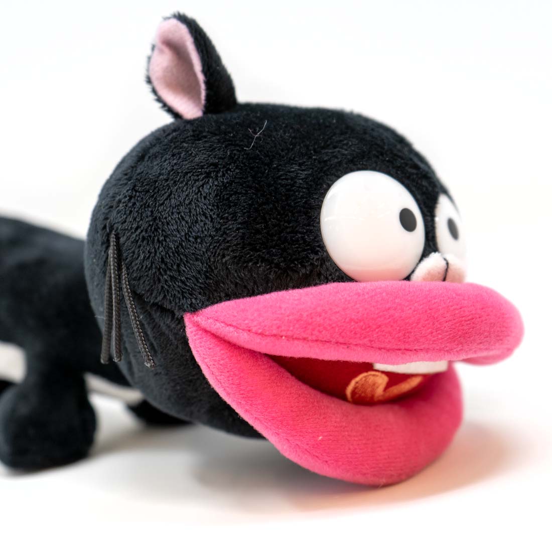 Plush toy of a cartoon cat with a long tongue on a white background
