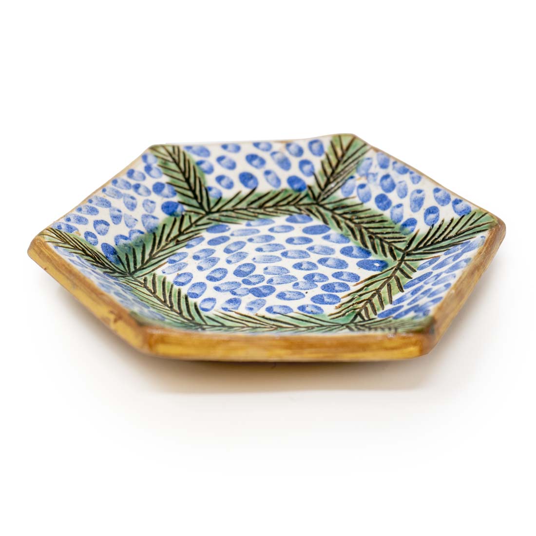 Hexagonal ceramic plate with blue and green pattern on a white background