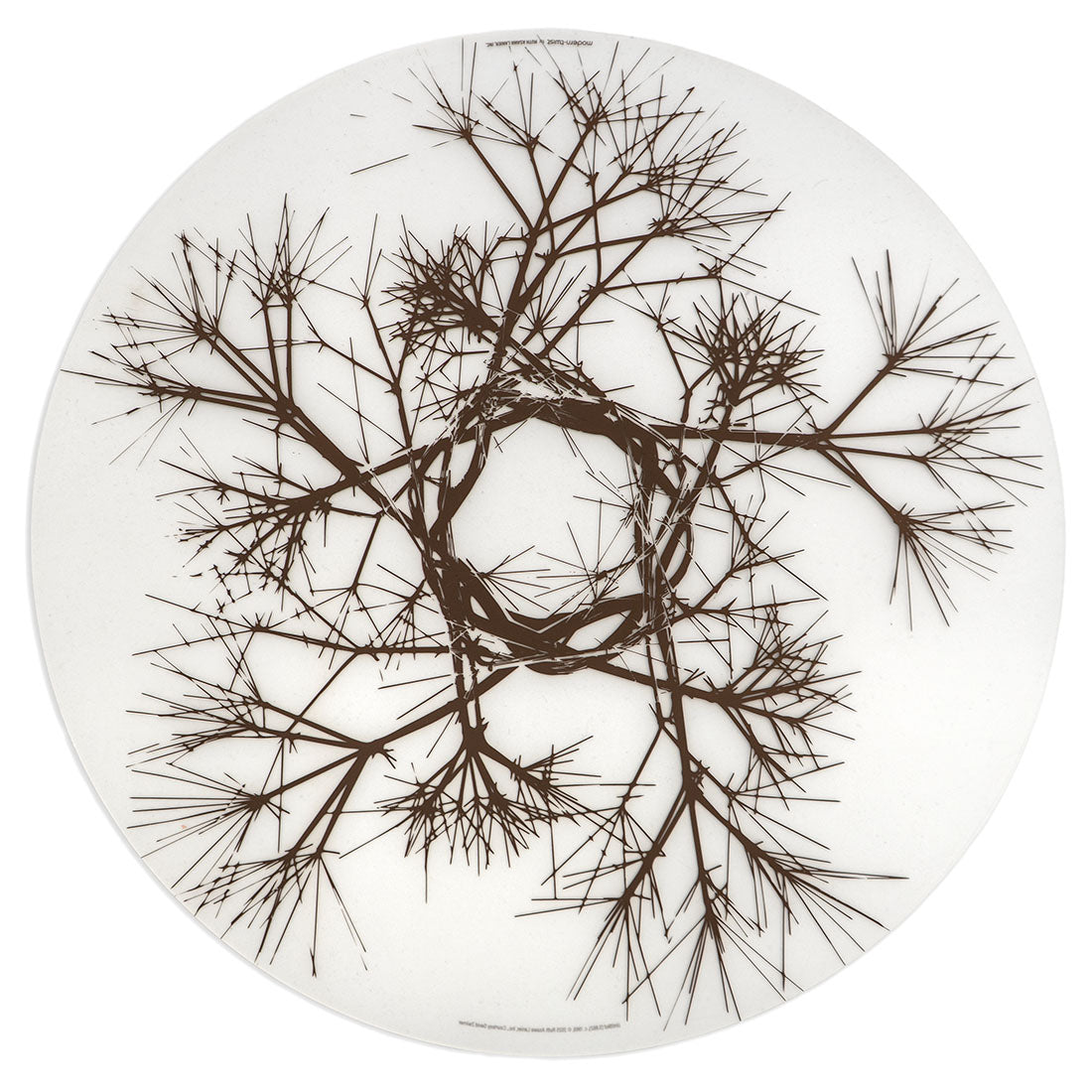 Round white plate with black branch-like design on a white background