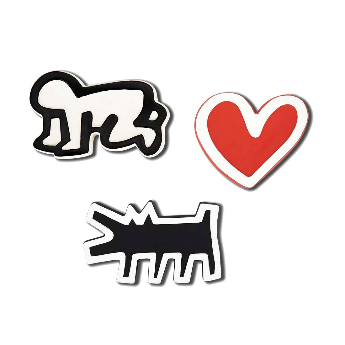 A set of three Keith Haring-themed bath toys, including a black and white dog, a red heart, and a black silhouette of a baby.