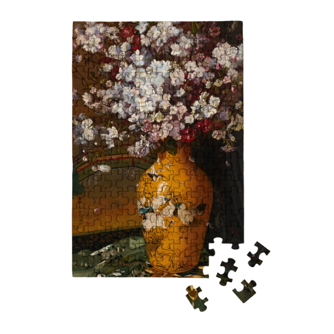 A completed floral jigsaw puzzle showing a large yellow-orange vase filled with white, pink, and burgundy flowers, with several loose puzzle pieces placed in front on a plain white background.