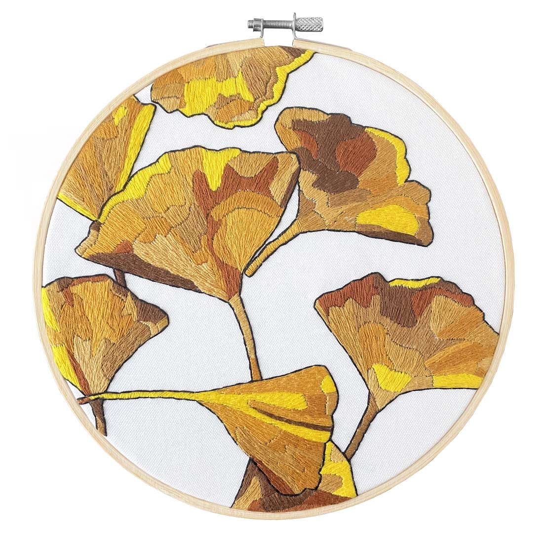 Embroidery hoop with yellow and brown leaf pattern on a white background