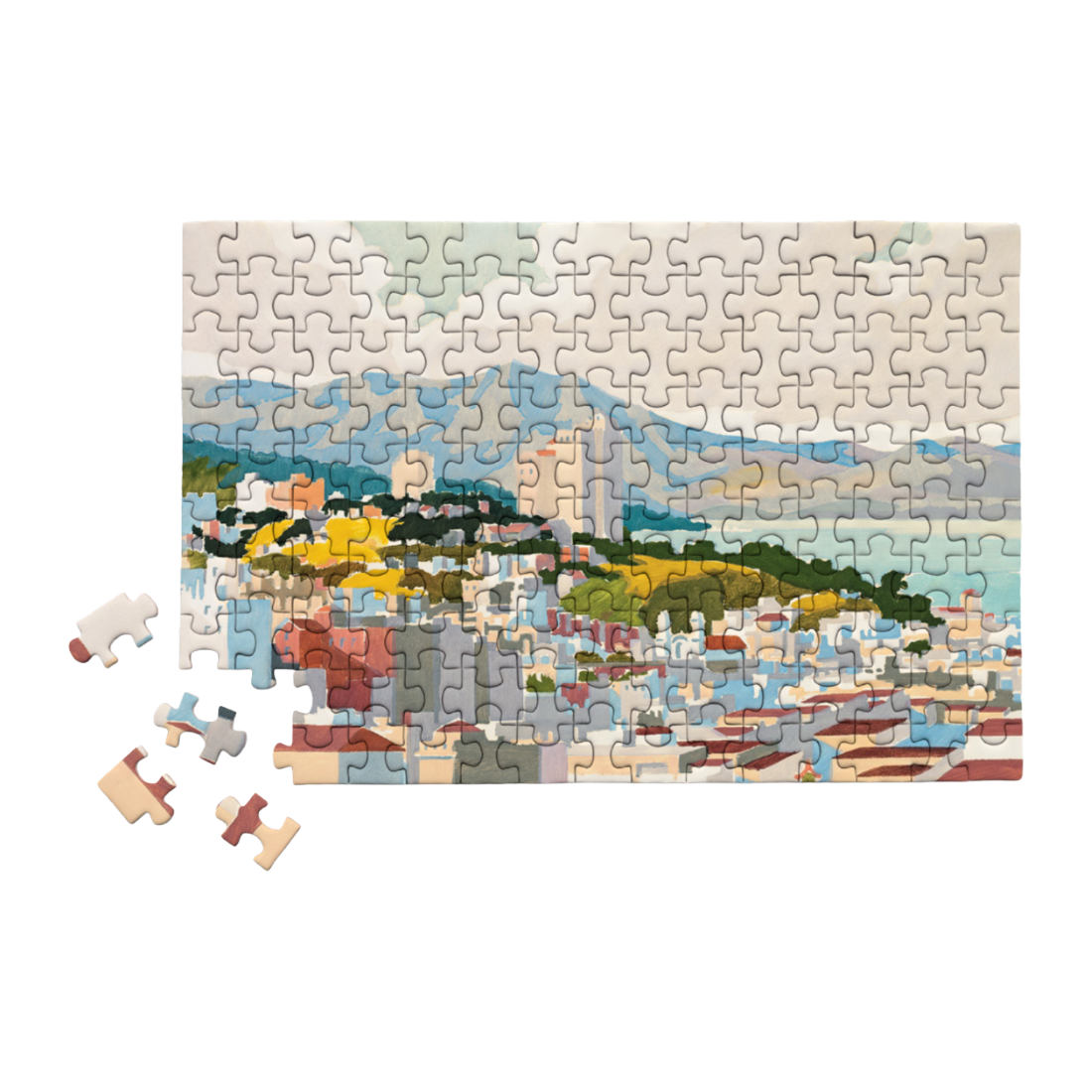 A completed jigsaw puzzle showing a coastal cityscape with blue water, green hills, and white buildings, displayed on a white background with four loose puzzle pieces beside it.
