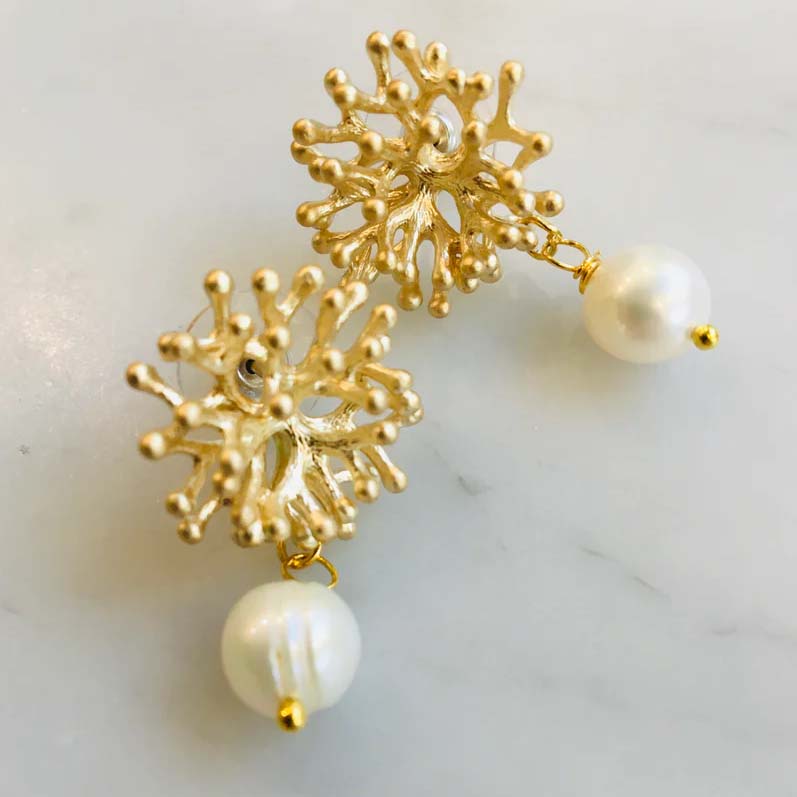 Gold coral-shaped earrings with pearl drops on a white background