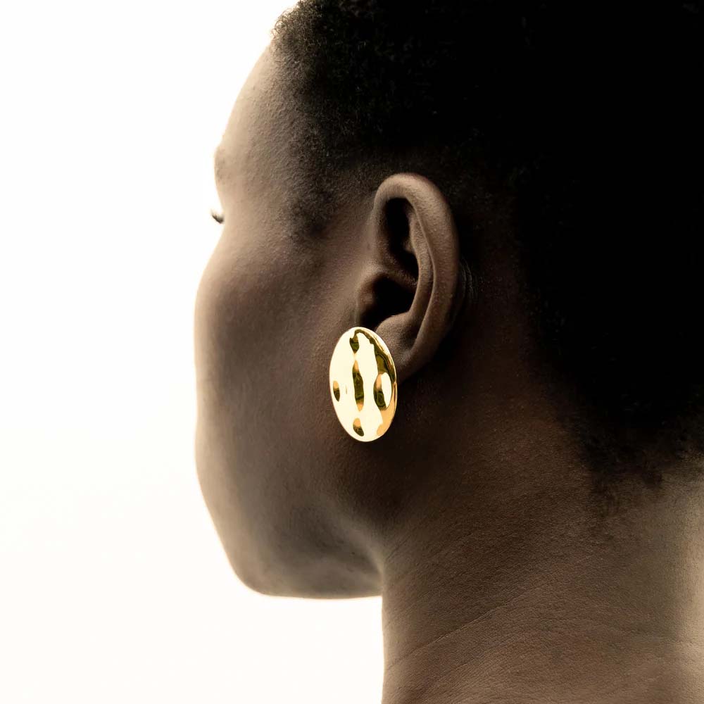 Pair of gold round earrings on a white background