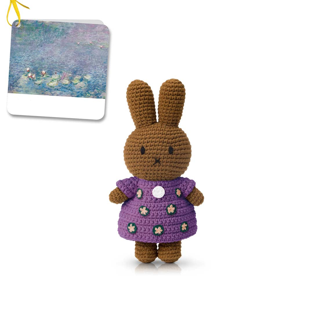 Crocheted toy rabbit with a purple dress on a white background
