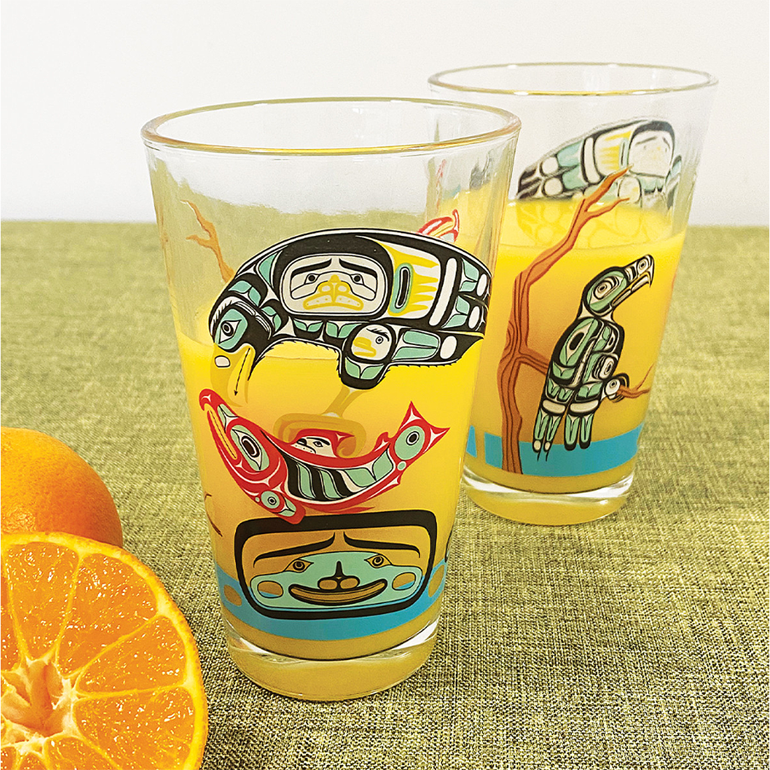 Two colorful glass tumblers with artistic designs on a white background