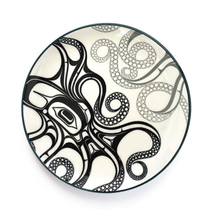 A round porcelain plate with a black and white octopus design, with a dark green rim.