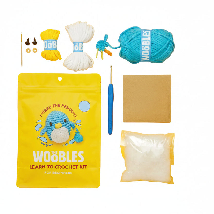 Woobles learn to crochet kit with yarn, hooks, and other supplies on a white background