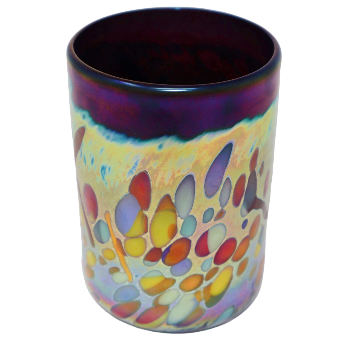 An iridescent glass cup with a colorful abstract pattern of orange, purple, yellow, and blue bubbles on a cream background, featuring a dark purple rim.