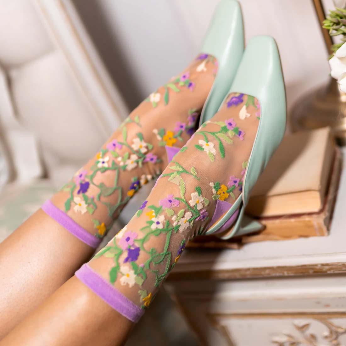 Floral patterned socks with purple accents on a white background