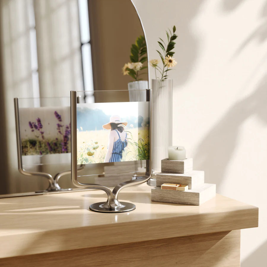 A silver, trophy-inspired, wishbone-shaped picture frame displaying a photo of a person in a field.