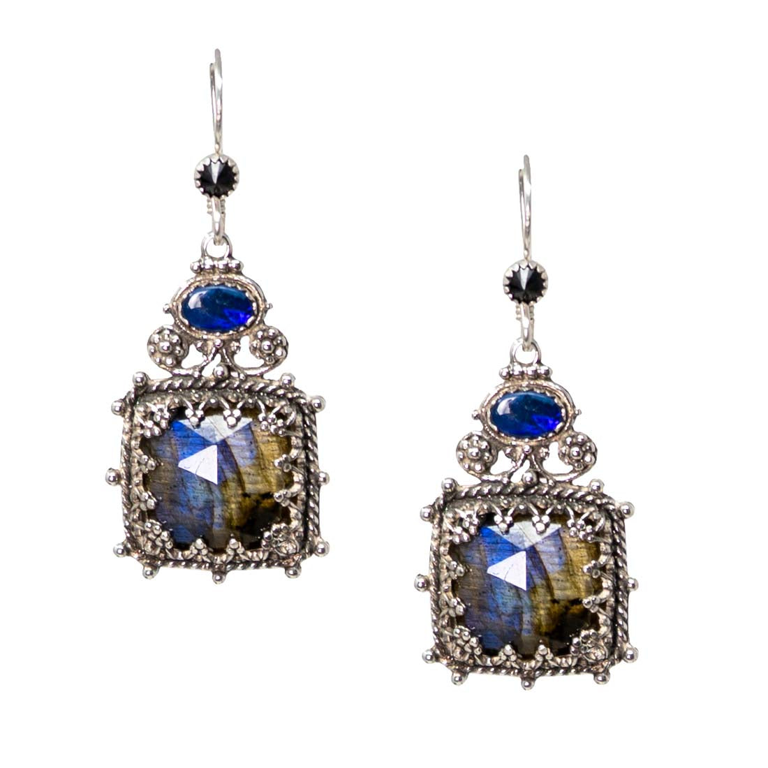 Pair of ornate earrings with blue and brown gemstones on a white background