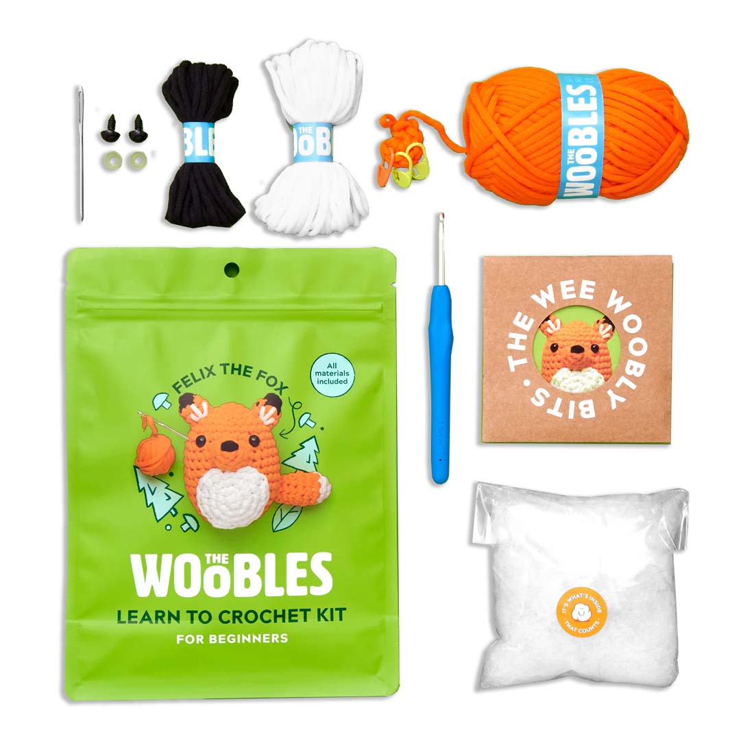 Crochet kit with yarn, hooks, and packaging on a white background