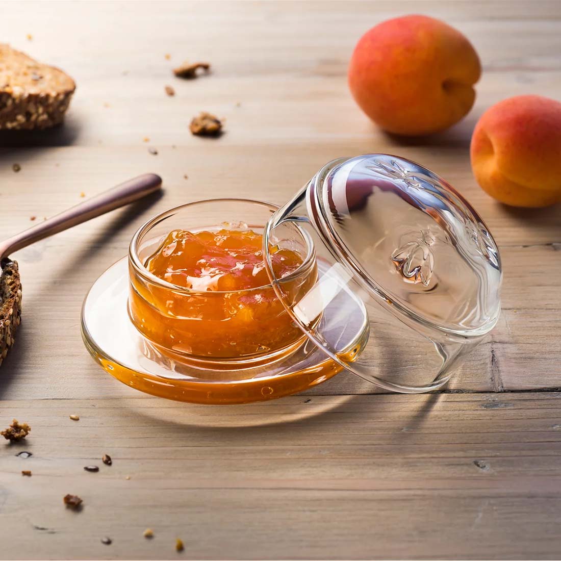 Clear glass butter dish with lid on a white background
