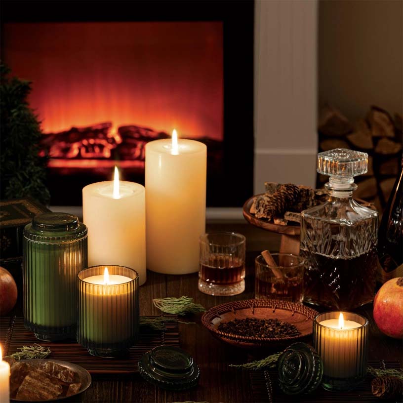 A green ribbed glass candle jar without a lid, designed for use with a candle.