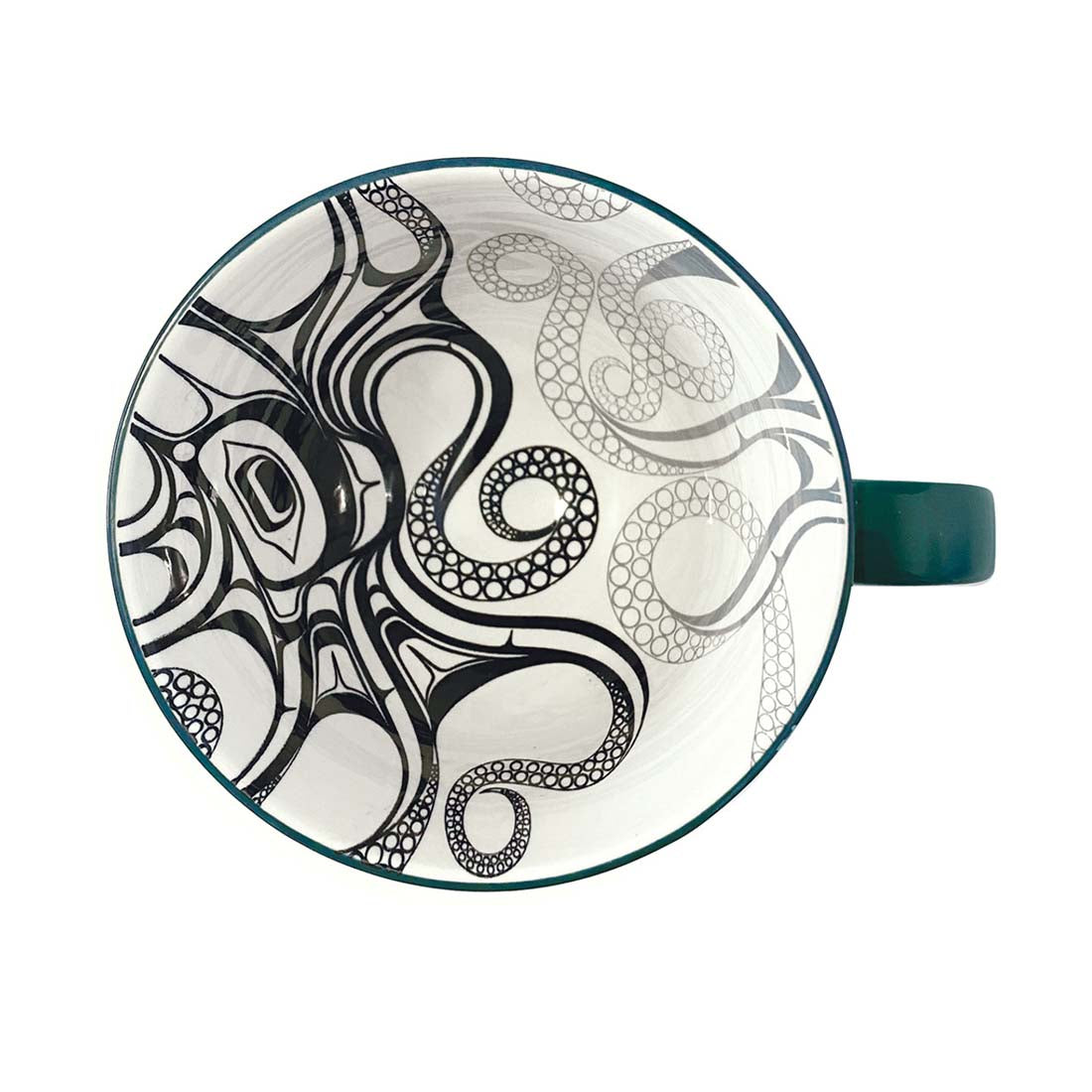A dark green ceramic mug with a contemporary Indigenous design on the interior and a textured exterior.