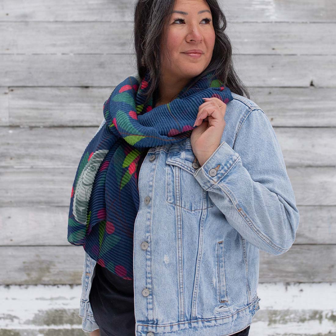 A scarf with a geometric pattern, featuring a mix of geometric shapes in various colors, displayed in a looped presentation.