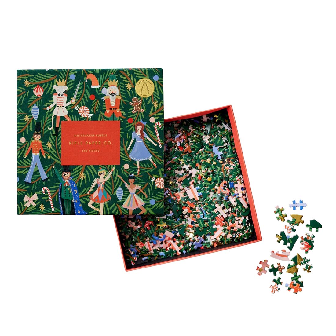 Jigsaw puzzle with illustrated characters on a green background, featuring the Rifle Paper Co. brand.