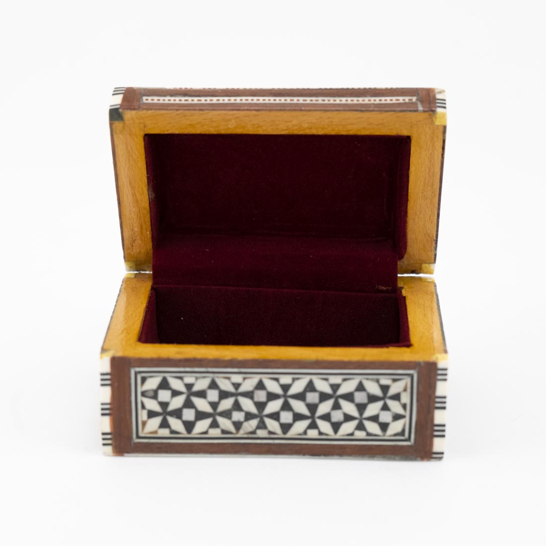 A small rectangular box with geometric mother-of-pearl inlays on the lid and a patterned fabric hinge.