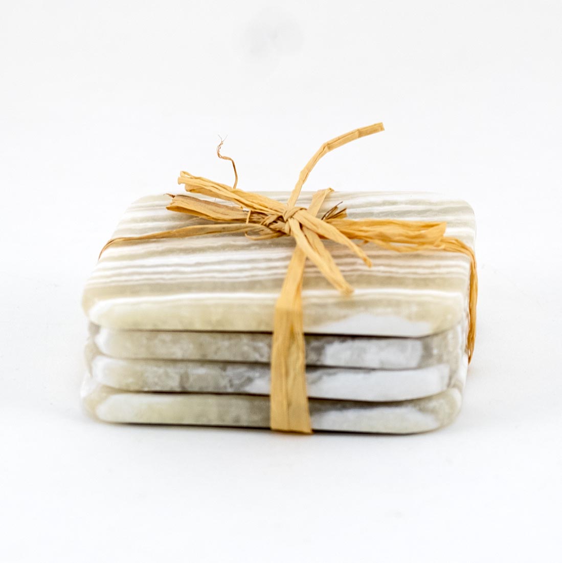 A set of four square alabaster coasters with variations in yellow and white colors.